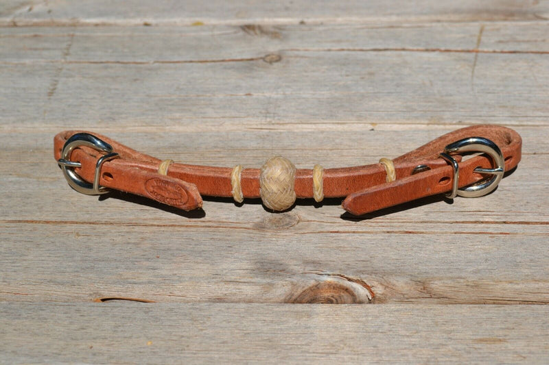 Handmade 1/2" conditioned harness leather curb strap with tightly braided natural rawhide rings and 1" center knot.  Conditioned leather has that already broken in feel.