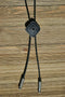 Close Up View Western Style Black Braided Leather Bolo Tie with amazing southwest design diamond shape concho slide with a matt black background and enamel center accent. 