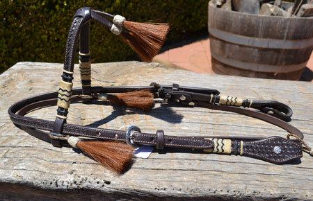 Collection image of Vaquero Brand Jose Ortiz Futurity Browband headstall with hand braided natural rawhide  with black detail and chestnut horsehair tassels.