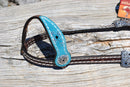 Close Up View 3/4" Memphis One Ear Headstall.  Made from dark brown leather with heavy white stitching.  Part of the Weaver Leather Common Threads Collection.   Cheek and ear piece have a turquoise suede leather overlay with stitched cross motif.  Genuine Swarovski crystals adorn the headstall and buckles.  Black tumbled leather ties at the bit ends.