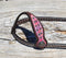 Close Up One Ear Detail Vintage Paisley One Ear Headstall.  Made from dark brown leather heavy denim style wheat colored stitching.  Part of the Weaver Vintage Paisley Collection.   Cheek and ear piece have a pink and orange overlay with small antiqued studs.  Tumbled leather ties at the bit ends.  Vintage style buckles are adjustable on both sides.