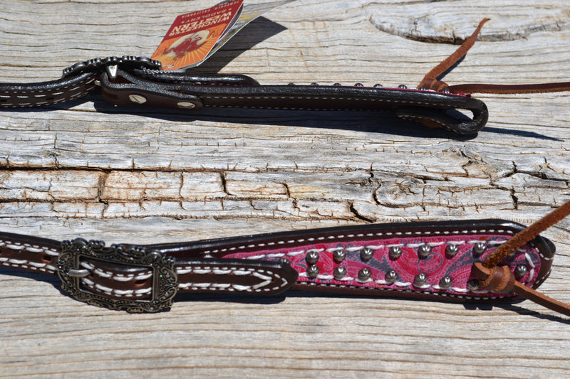 Close Up View Vintage Paisley One Ear Headstall.  Made from dark brown leather heavy denim style wheat colored stitching.  Part of the Weaver Vintage Paisley Collection.   Cheek and ear piece have a pink and orange overlay with small antiqued studs.  Tumbled leather ties at the bit ends.  Vintage style buckles are adjustable on both sides.