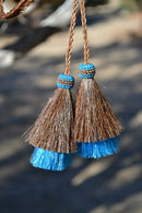 Super Close Up View natural horse hair Stampede String with two bell mule tail cut tassels and cotter pin attachments. 
