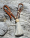 1/2" light russet oil leather curb strap with tightly braided natural rawhide knot and light grey mane horsehair tassel.