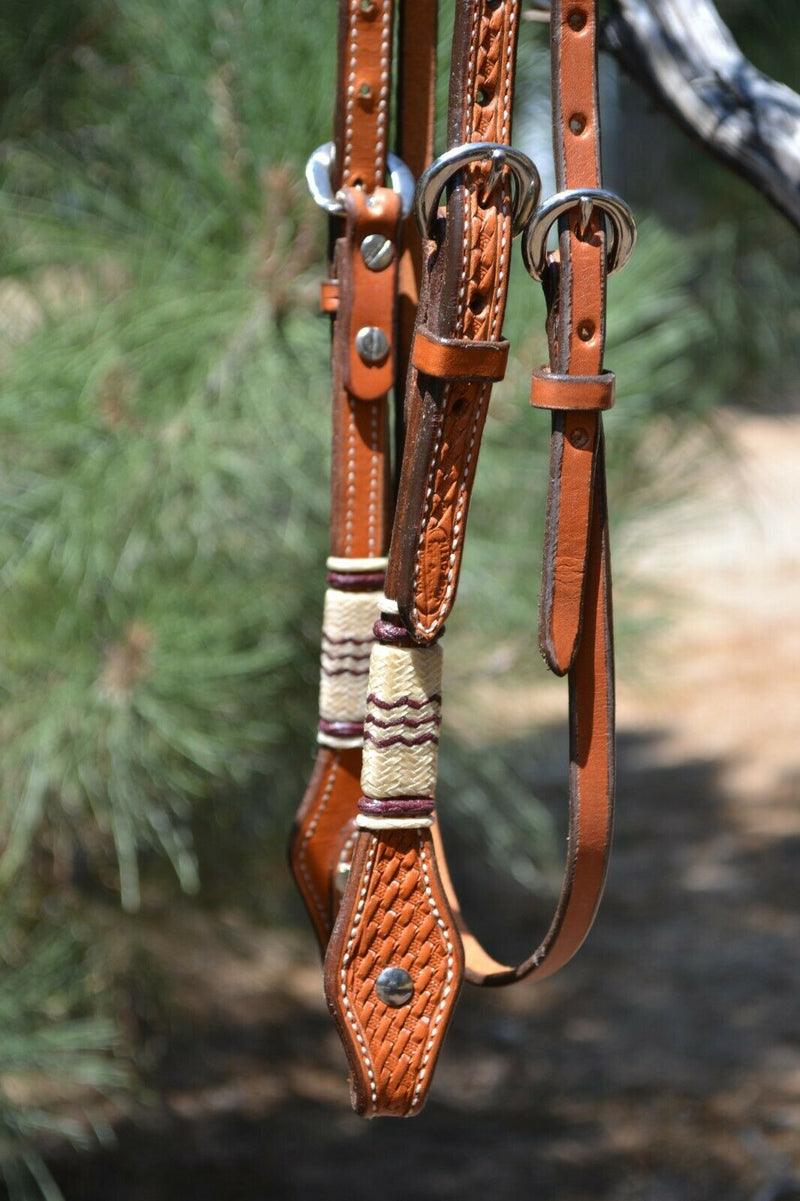 Close Up View Jose Ortiz 5/8" Straight Browband Headstall.  Constructed of two-ply and stitched russet oil  finished leather.  Hand carved with Jose's signature basket weave tooling and natural hand braided rawhide with latigo brown details on cheek pieces and browband.  