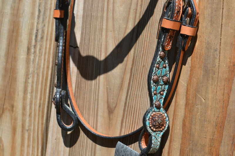 Close Up View Bit ends Circle Y of Yoakum -  Custom 5/8" Scalloped Browband Gag Headstall  with floral tooling with antiqued wash on crown.   Browband and cheek pieces have turquoise faux gator overlay accented with antiqued parachute spots.   Antiqued copper conchos on browband and bit ends. 