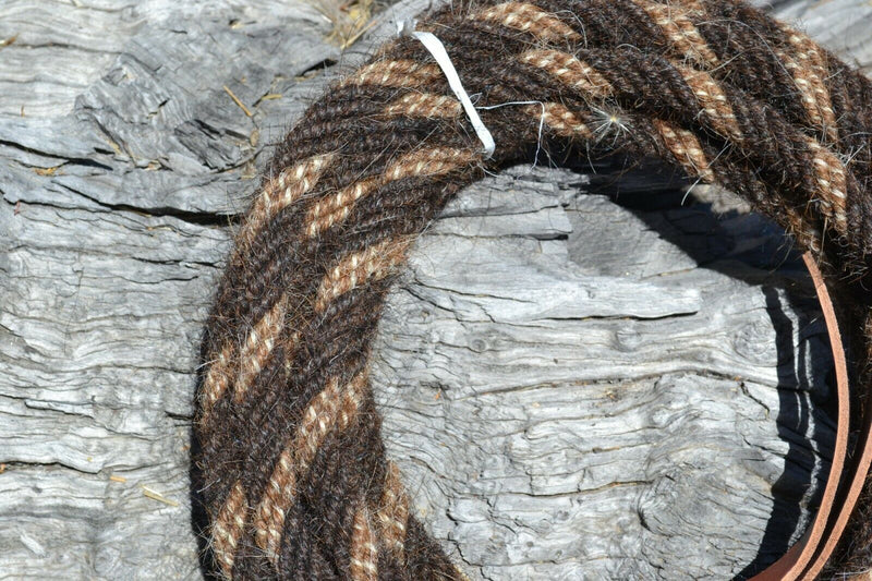 Close Up View Hand made by Jose Ortiz, 5/8" x 22' mecate made from 6 tightly hand twisted strands of  super dark liver chestnut, sorrel & white mane hair with a soft leather popper at one end turks head knot on the other.  