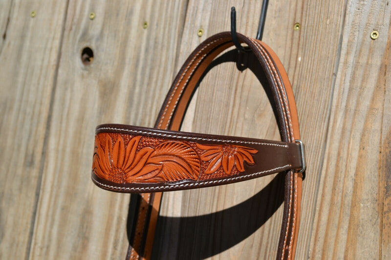 Close Up View Browband Wide browband headstall with Sunflower Tooling with two-tone chocolate colored leather and natural tooling.  Accented with arrow motif double adjustment buckles and leaf conchos.     Actual headstall differs slightly from manufacturer canned photo.  Headstall shown in live photos is the one you will receive with the arrow buckles.  Horse size.