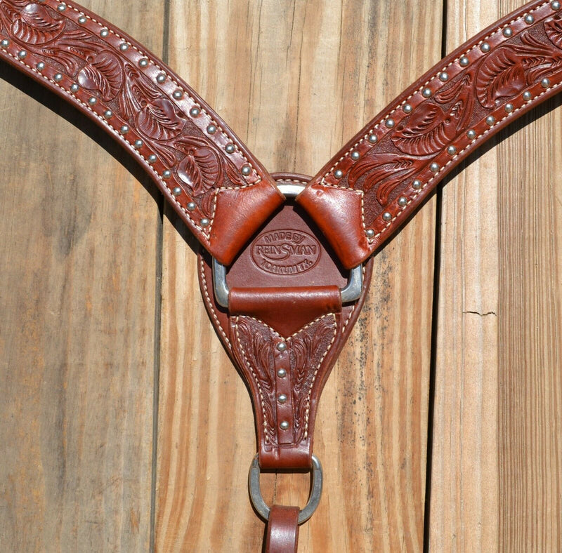 Close Up View Reinsman Heavy Duty 2" Heavy Oil Double Ply Harness Leather Breast Collar with Hand Carved Arizona Flower tooling with spots.  Stainless steel hardware and tugs and cinch drop.   1" x 12" adjustable tugs. 