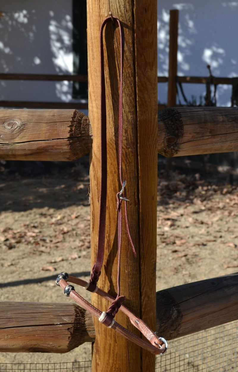 Jose Ortiz has made these beautiful rolled harness leather adjustable western training cavesons with latigo hangers.   Made from beautifully conditioned Hermann Oak harness leather with 3 natural and black and natural rawhide knots over the nose and natural rawhide hanger knots. 
