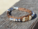 Close Up View Awesome 3/8" wide, 3 Strand Braided Horsehair Bracelet with a lobster claw clasp and various colored and patterned bone beads. Sorrel/Silver