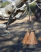 Close Up View natural horse hair Stampede String with two bell mule tail cut tassels and cotter pin attachments.     Black/Chestnut/Black