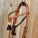 Close Up VIew 5/8" Futurity / Cross-Over Browband Headstall with black horse hair tassels and natural/black rawhide buttons.     Made from two-ply and stitched regular oil leather with removable stainless steel buckles that are adjustable on both sides and latigo ties at bit ends