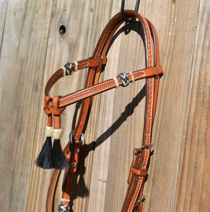 Close Up VIew 5/8" Futurity / Cross-Over Browband Headstall with black horse hair tassels and natural/black rawhide buttons.     Made from two-ply and stitched regular oil leather with removable stainless steel buckles that are adjustable on both sides and latigo ties at bit ends