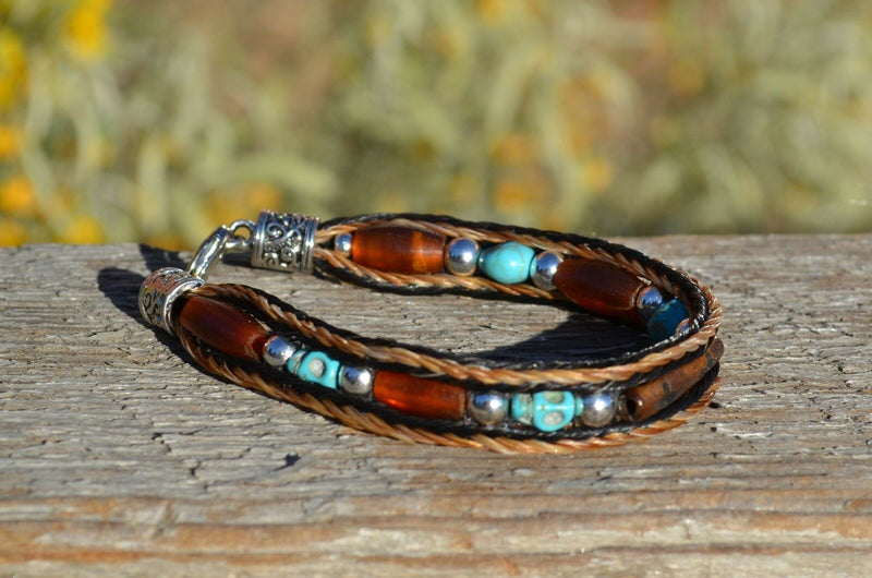 Close Up View Awesome 3/8" wide, 3 Strand Braided Horsehair Bracelet with a lobster claw clasp and various colored and patterned bone beads. Chestnut/Black/Turquoise/Skull