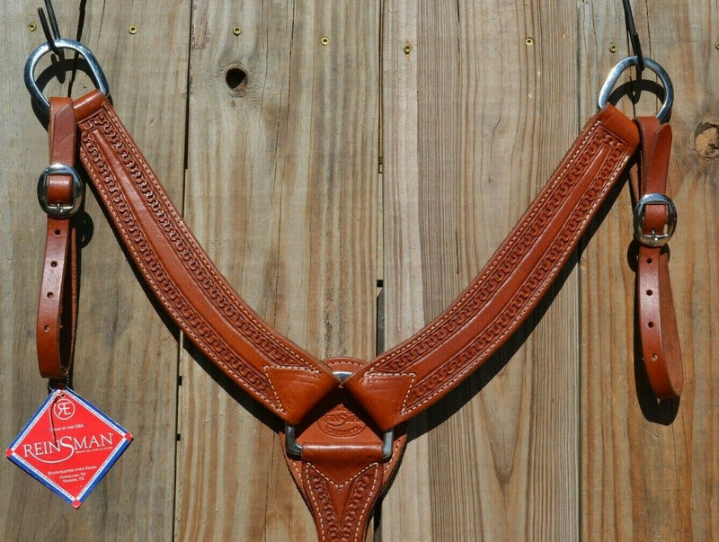 Reinsman Heavy Duty 2" Double Ply Leather Breast Collar with Hand Carved with Snake border tooling.  The chest pieces are swept upwards like a martingale style breast collar for less restrictive shoulder movement, however, it has standard tugs.  Medium honey color leather.  