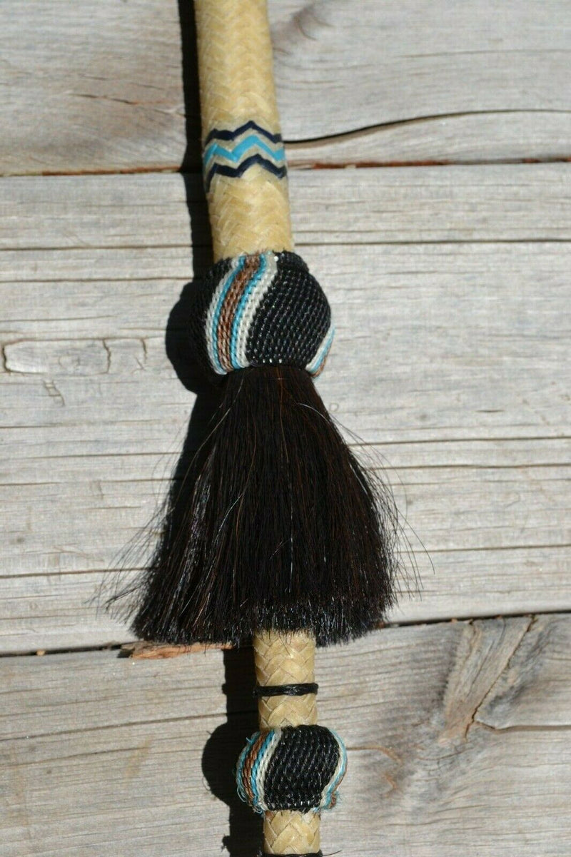 Super Close Up View Beautiful Jose Ortiz Braided Rawhide Quirt Whip with Hitched Horsehair Knots, black horsehair tassels and Hand Tooled Leather Popper. Natural colored rawhide with turquoise blue, tan and black details. 
