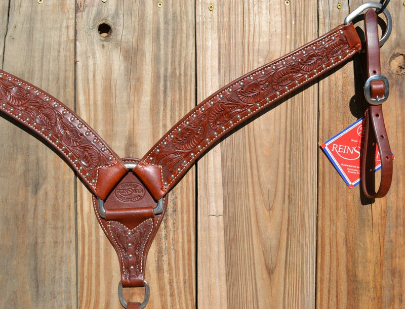 Close Up View Reinsman Heavy Duty 2" Heavy Oil Double Ply Harness Leather Breast Collar with Hand Carved Arizona Flower tooling with spots.  Stainless steel hardware and tugs and cinch drop.   1" x 12" adjustable tugs. 