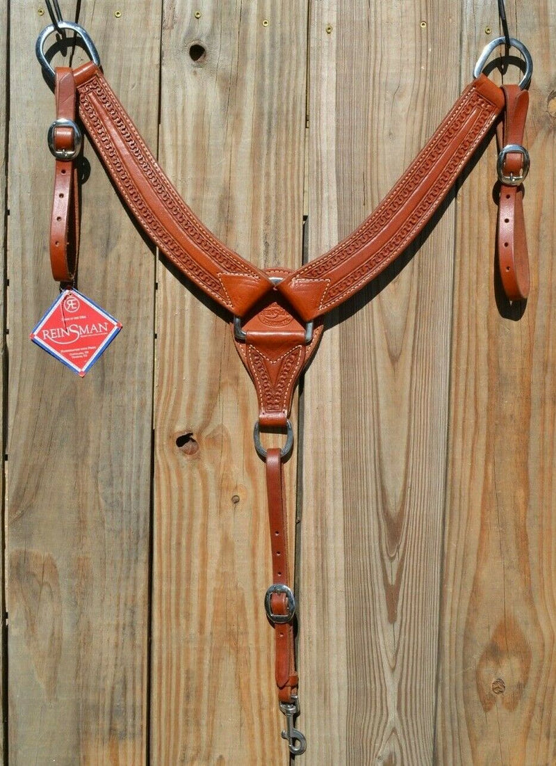 Reinsman Heavy Duty 2" Double Ply Leather Breast Collar with Hand Carved with Snake border tooling.  The chest pieces are swept upwards like a martingale style breast collar for less restrictive shoulder movement, however, it has standard tugs.  Medium honey color leather.  