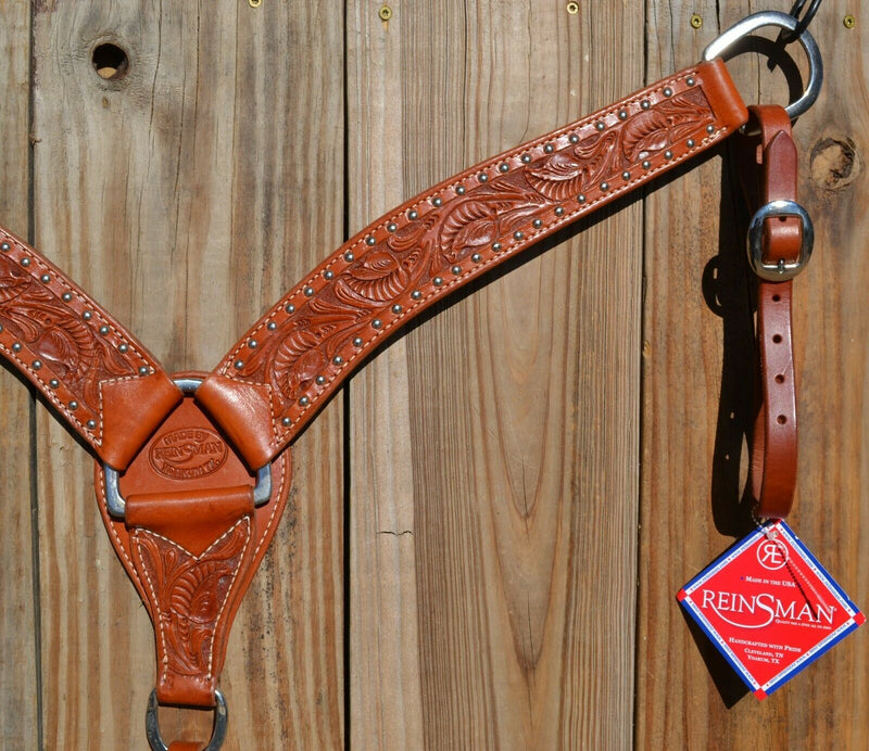 Close Up View Reinsman Heavy Duty 2" Double Ply Leather Breast Collar with Hand Carved Arizona Flower tooling with spots.  Warm light mahogany color leather.  Stainless steel hardware and tugs and cinch drop.   1" x 12" adjustable tugs. 