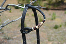 Close Up View Single Ear Jose Ortiz 5/8" One Single Ear Headstall.  Constructed of two-ply and stitched black finished leather.  Hand carved with Jose's signature basket weave tooling and natural hand braided rawhide with burgundy latigo details on cheek pieces and ear pieces.   
