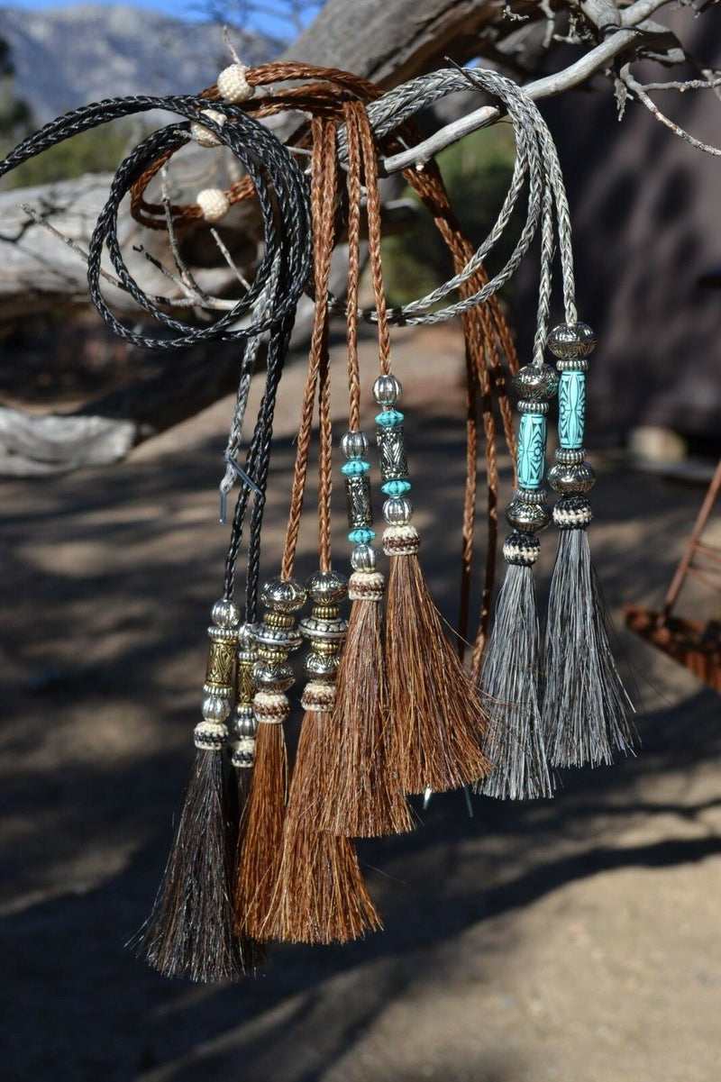 Close Up View Various Colors  natural horse hair stampede string with beads and horse hair tassels and cotter pin attachments.
