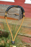 1/4" hand braided dark natural rawhide pencil bosal with a rawhide core and black calf leather nose and knot with tan details.  Noseband measures 1/2" wide at the thickest point. 