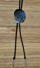 Close Up View Western Style Black Braided Leather Bolo Tie with Southwestern Silver toned concho slide with matt black enamel inlay and silver tips.   