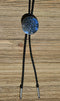 Close Up View Western Style Black Braided Leather Bolo Tie with Southwestern Silver toned concho slide with matt black enamel inlay and silver tips.   