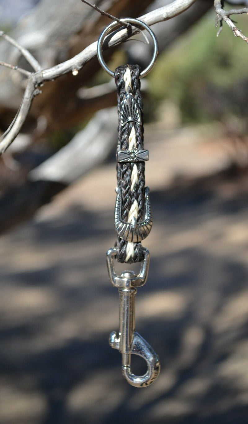 Close Up View Handmade natural horsehair braided key chain with silver tone faux buckle and snap. This key chain is about 6" long including the 1" key ring loop to connect the keys.    Black/White
