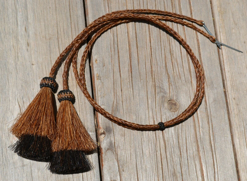 Close Up View natural horse hair Stampede String with two bell mule tail cut tassels and cotter pin attachments. Chestnut/Chestnut/Black