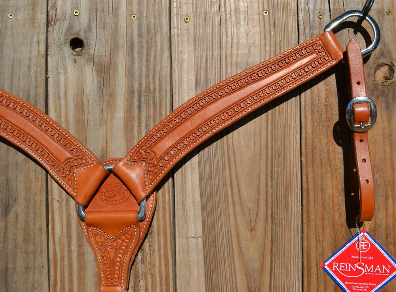 Reinsman Heavy Duty 2" Double Ply Leather Breast Collar with Hand Carved with Snake border tooling.  Light honey color leather.  Stainless steel hardware and tugs and cinch drop.   1" x 12" adjustable tugs. 