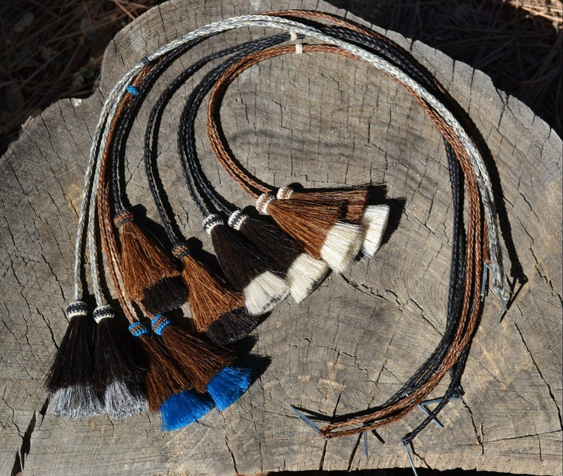 Close Up View Various Colors natural horse hair Stampede String with two bell mule tail cut tassels and cotter pin attachments. 