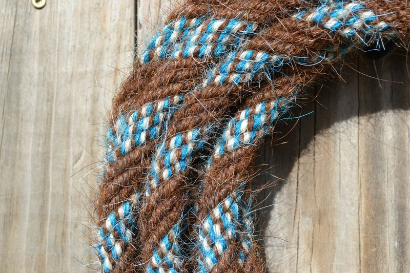 Close Up View Hand made by Jose Ortiz, 5/8" x 22' mecate made from 6 tightly hand twisted (not machine twisted) strands of chestnut, white & turquoise  color mane hair with a soft leather popper at one end turks head knot on the other.  