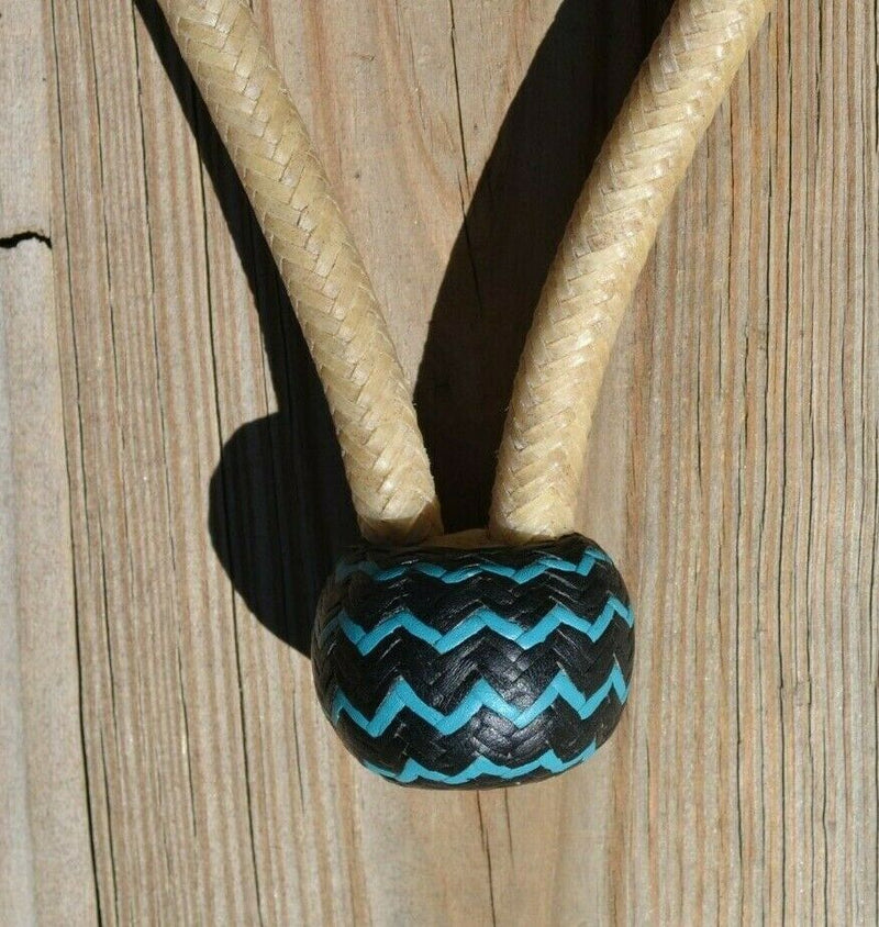 Close Up View Knot. Jose Oritz 1/2" hand braided natural beveled rawhide bosal with natural rawhide with black leather nose with turquoise details and a traditional round shaped knot with a space between the cheek pieces.