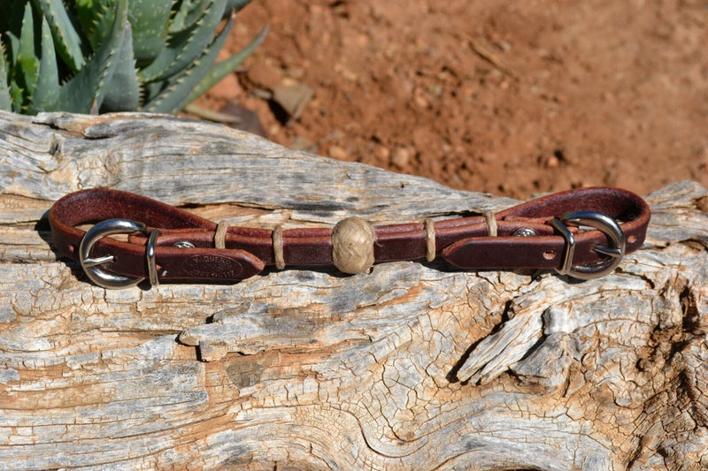Handmade 1/2" latigo leather curb strap with tightly braided natural rawhide rings and 1" center knot.  