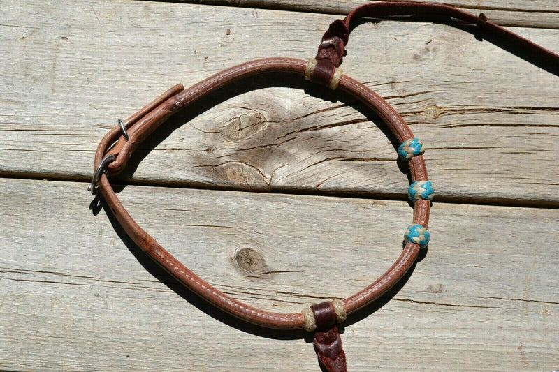 Jose Ortiz has made these beautiful rolled harness leather adjustable western training cavesons with latigo hangers.   Made from beautifully conditioned Hermann Oak harness leather with 3 natural and turquoise rawhide knots over the nose and natural colored rawhide hanger knots.  