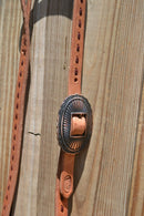 Close Up View Buckle Jose Ortiz 3/4" One/Single Split Ear Headstall.  Constructed of single-ply natural harness leather with latigo leather buck stitching.   Removable antiqued copper color concho buckle and latigo ties the bit ends.  