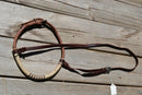 rolled harness leather adjustable western training cavesons with latigo hangers.   Made from beautifully conditioned Hermann Oak harness leather with full braid natural rawhide with burgundy latigo accents over the nose and natural rawhide hanger knots. 