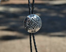 Super Close Up View Western Style Black Braided Leather Bolo Tie with Southwestern Silver toned concho slide with matt black enamel inlay and silver tips.   