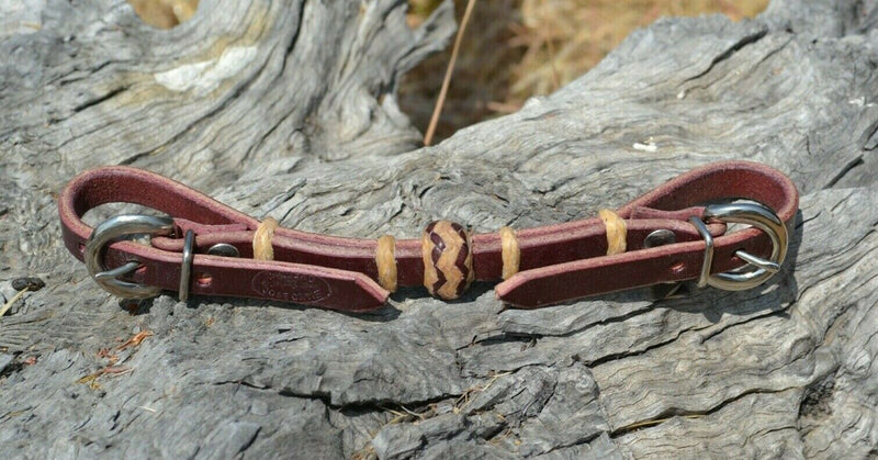 Handmade 1/2" burgundy latigo leather curb strap with tightly braided golden natural rawhide rings and 1" center knot with latigo brown details.  Adjusts up to 9" long with the double stainless steel buckle ends.