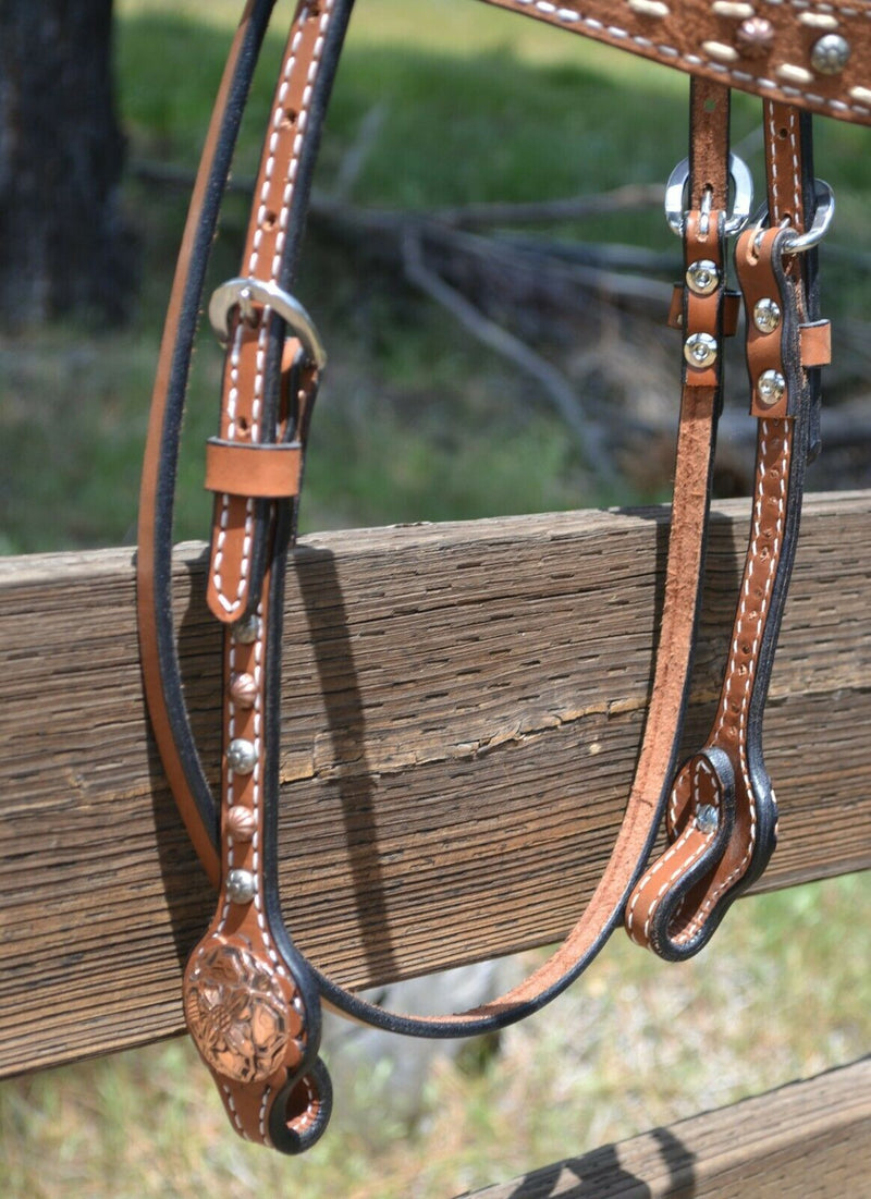 Close Up Bit Ends Side View Circle Y of Yoakum - 5/8" Straight Flare Browband Headstall with Rough Out Brow Overlay with buckstitching and Antiqued Copper Spots and Copper Floral Conchos at bit ends. 