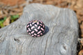 Close up View Hand braided rawhide scarf slide. Custom made in two-tone combinations of black and bright colored leather braided in a custom "checkerboard" pattern.   Pink/Black