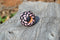 Close up View Hand braided rawhide scarf slide. Custom made in two-tone combinations of black and bright colored leather braided in a custom "checkerboard" pattern.    Pink/Black