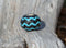 Hand braided rawhide scarf slide.  Custom made in two-tone combinations of black and bright colored leather braided in a "zig zag" pattern.Turquoise/Black